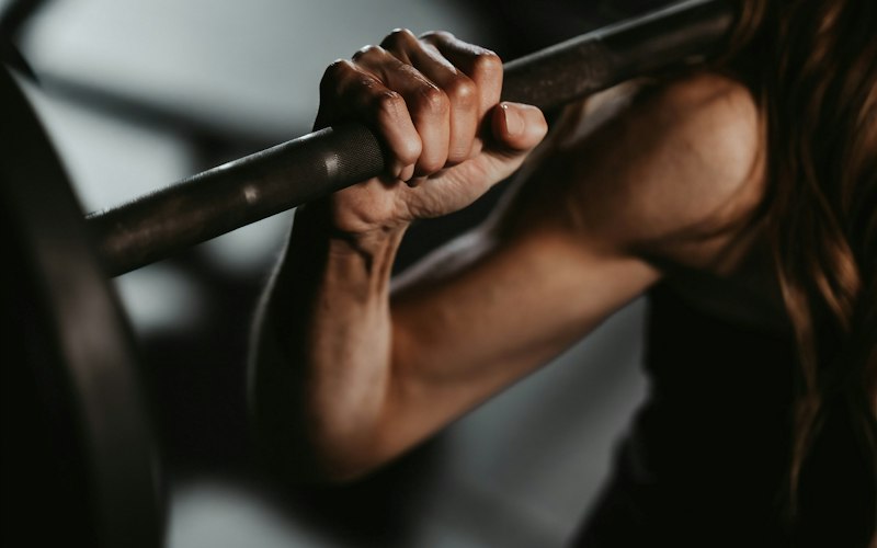 Person lifting a barbell as part of a structured strength training programme